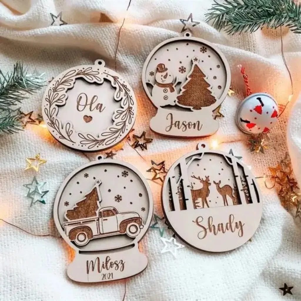 Four personalized wooden Christmas ornaments: snow globe, wreath, truck, and deer scene. Names included.