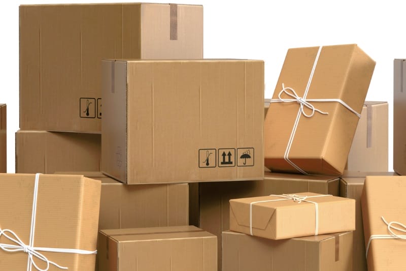 Stack of cardboard boxes, some tied with twine, ready for shipping.